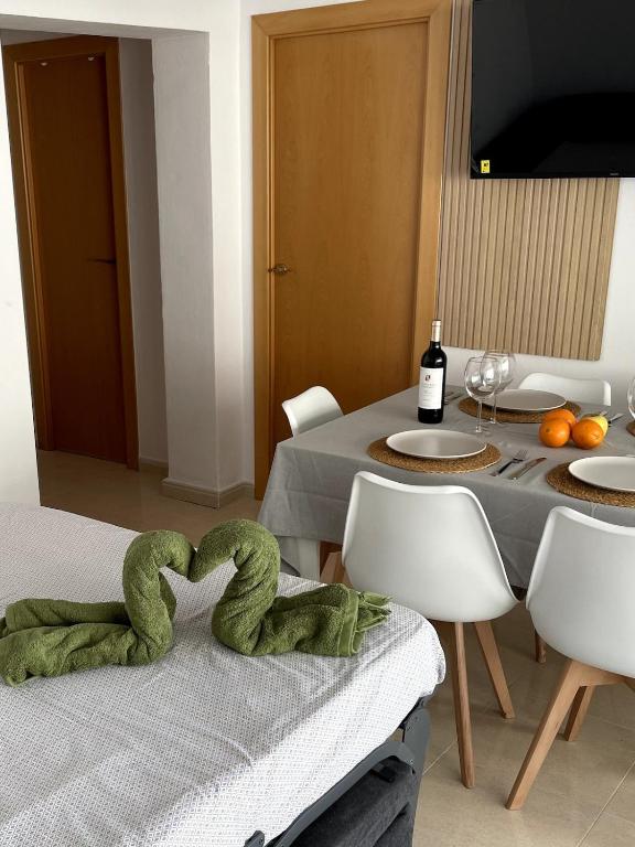 a dining room with a table with a green towel at Apartament Mar Beach Lloret II Aqua in Lloret de Mar