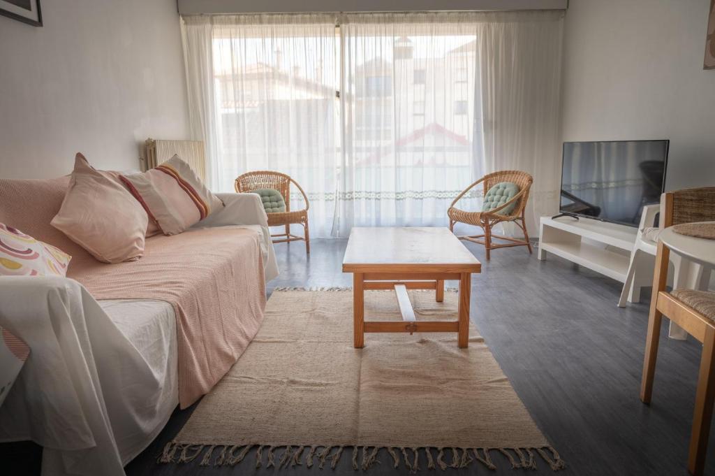 un salon avec un canapé et une table dans l'établissement Appartement Les Coraux, centre & plage, à Arcachon