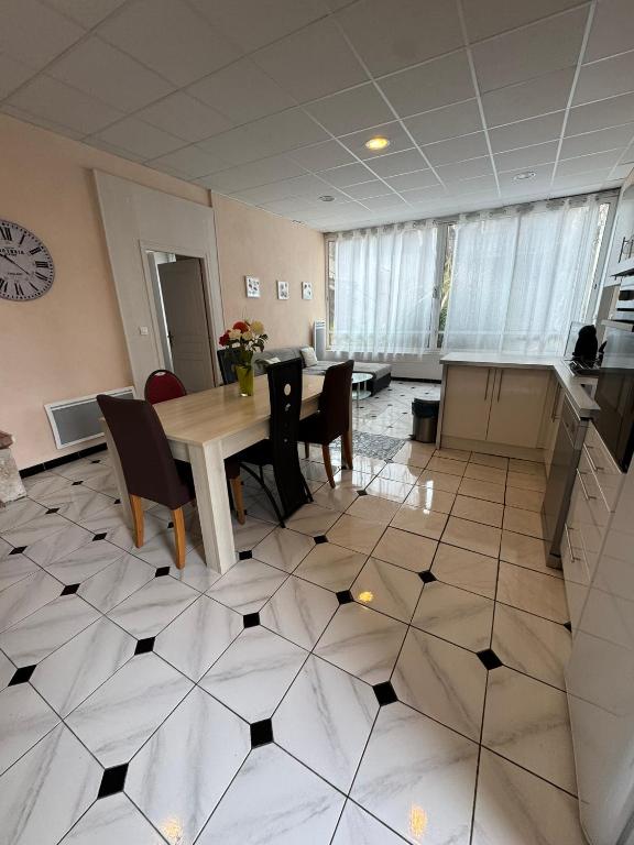 a room with a table and chairs on a tiled floor at Aquanerius Résidence in Néris-les-Bains