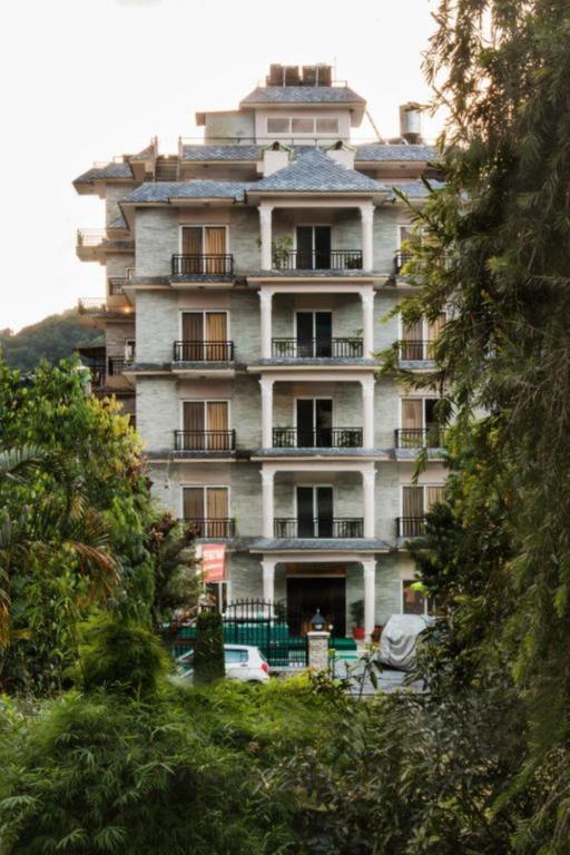 a tall building with cars parked in front of it at Pokhara Crown Plaza in Pokhara