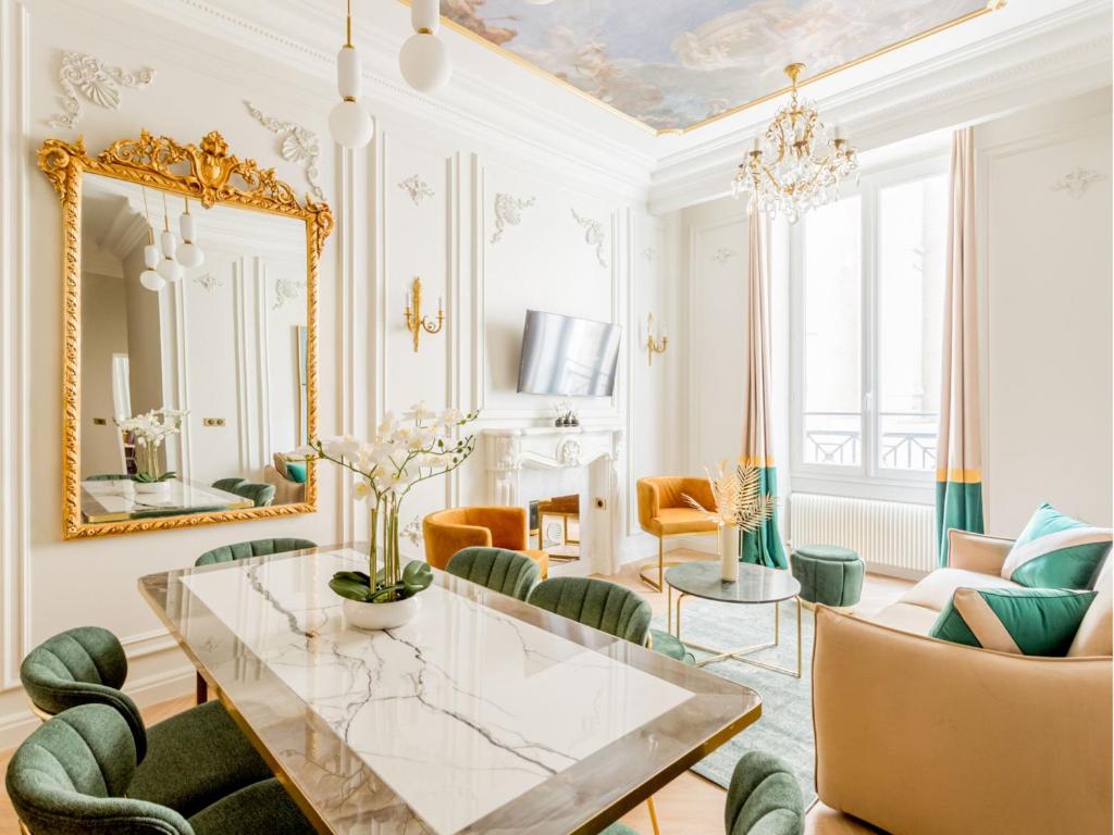 une salle à manger avec une table en verre et des chaises vertes dans l'établissement Merveil - Luxury Suite -Opera - Volney II, à Paris