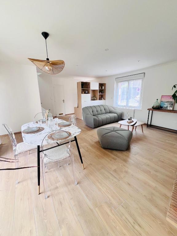 un salon avec une table et un canapé dans l'établissement Maison entièrement rénovée Plérin centre, à Plérin