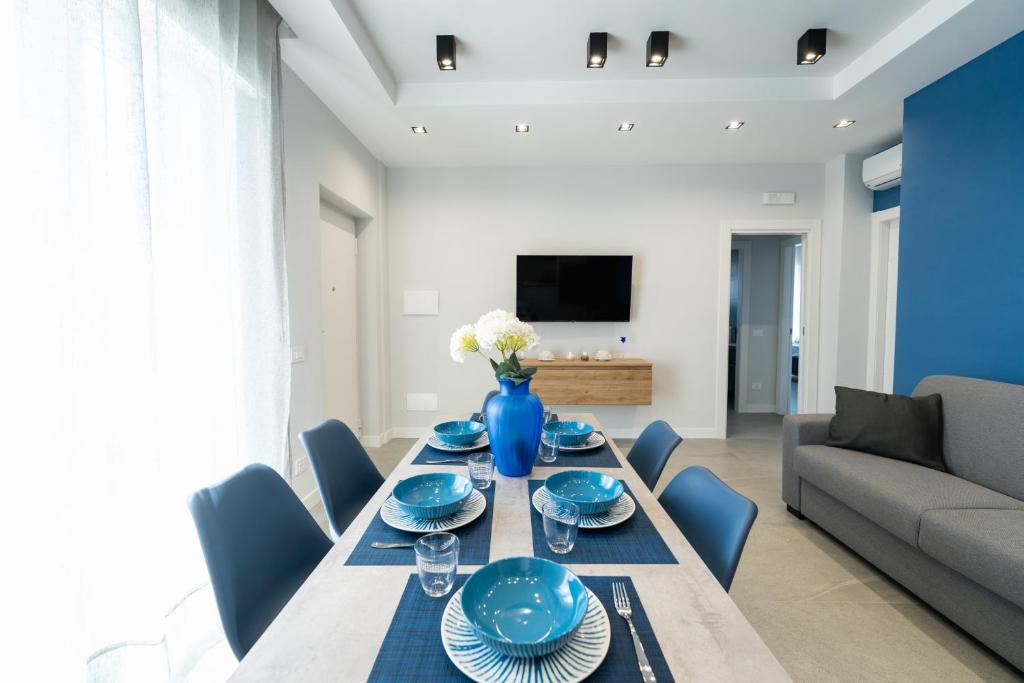 een eetkamer met een tafel met blauwe gerechten. bij Villa Cola - Vesuvio Garden & Relax in Boscotrecase