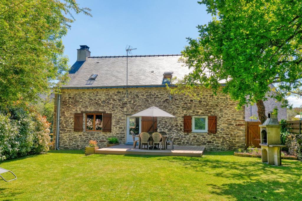 Cette maison en pierre possède une terrasse dans la cour. dans l'établissement Maison avec grand jardin 10km plage, à Férel