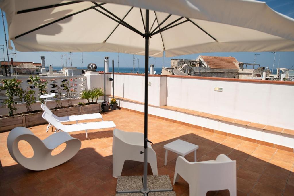 a patio with an umbrella on a roof at Old town apartment with sea view private rooftop in Giovinazzo