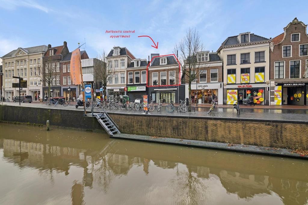 a city with a river and buildings and a street at Authentic sleeping in the city center in Leeuwarden
