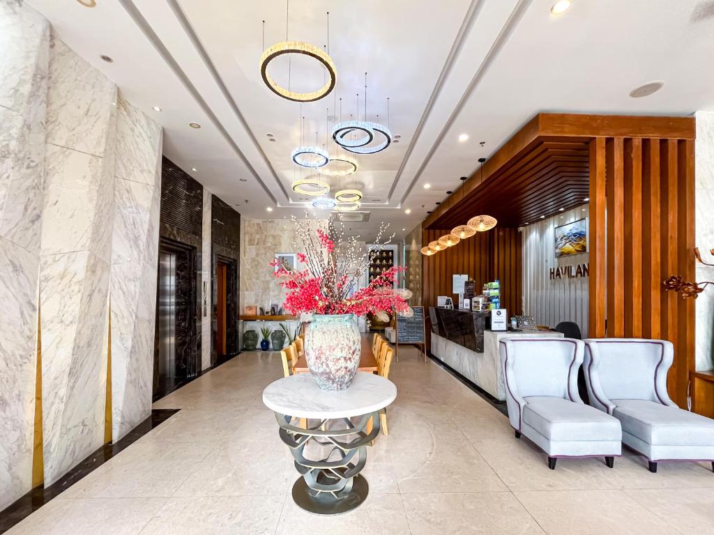 A polished hotel lobby with marble finishes, decorative lighting, and a reception area.