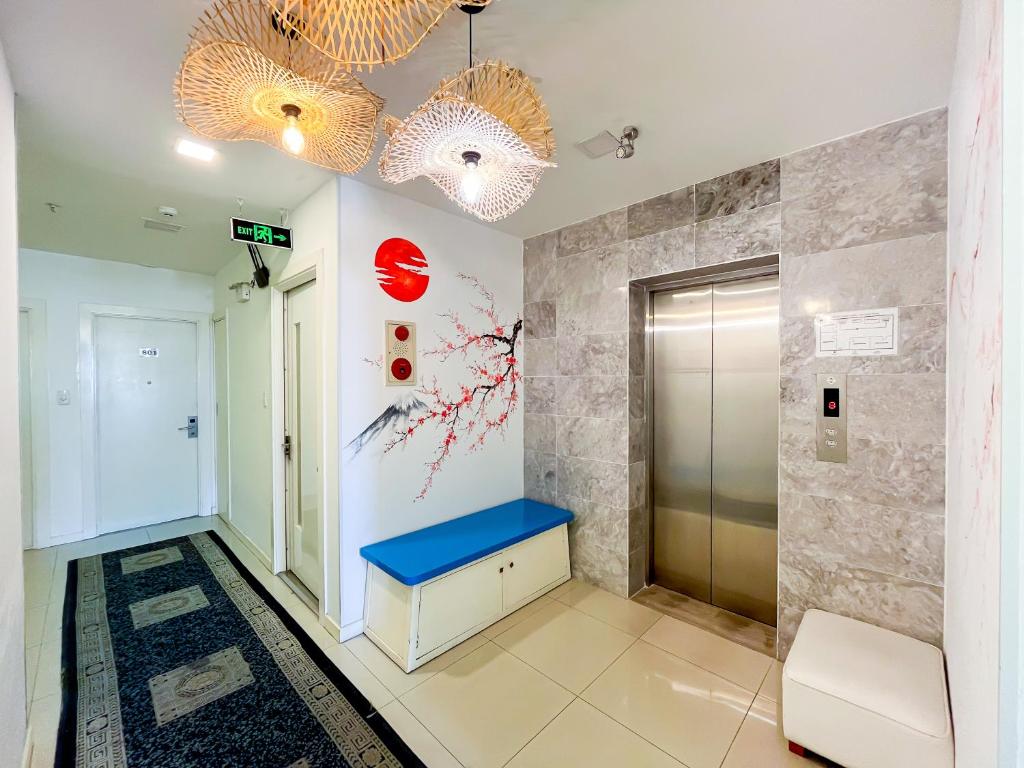 An elevator landing with a blue bench, patterned runner and decorative pendant lights.