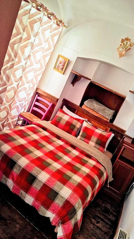 une chambre avec un lit avec une couverture à carreaux dans l'établissement Location appartement village, à La Celle-sous-Gouzon