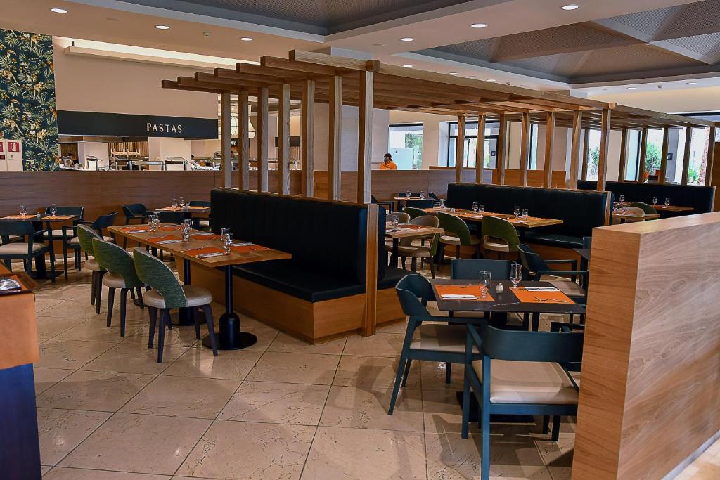 a dining room with tables and chairs in a restaurant at Puerto Antilla Grand Hotel in Islantilla