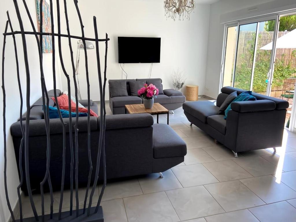 un salon avec deux canapés et une télévision dans l'établissement Les 3 Cépages - Gîte, à Épernay