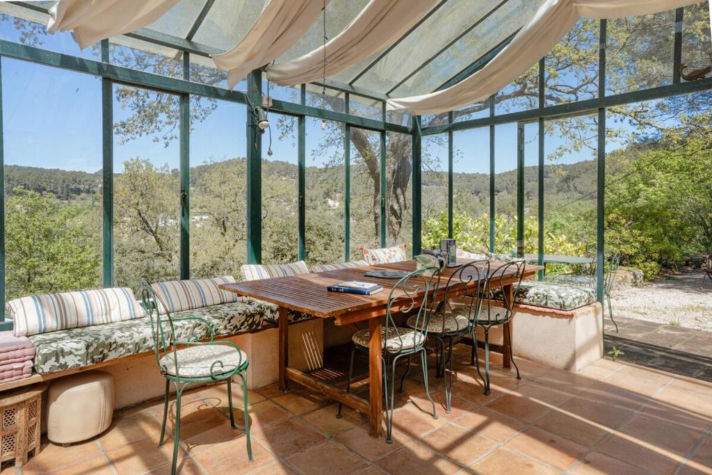 une salle à manger avec une table, des chaises et des fenêtres dans l'établissement Bastide Provençale avec piscine, à Aix-en-Provence