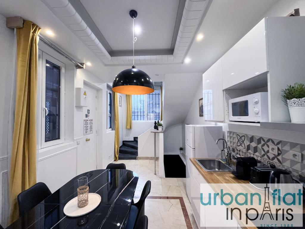 une cuisine et une salle à manger avec une table et des chaises dans l'établissement Urban Flat 80 - Paris Cinema Sebastopol, à Paris
