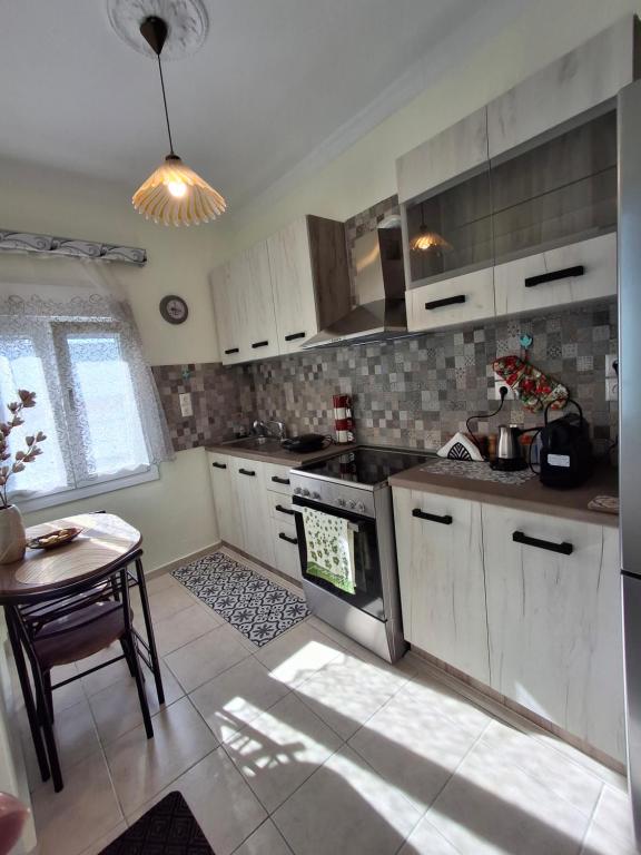 a kitchen with a stove and a table in it at Lovely House in Mytilene