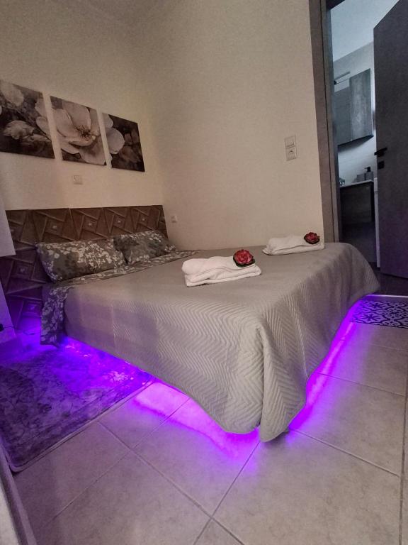 a bedroom with a bed with purple lights on the floor at Lovely House in Mytilini