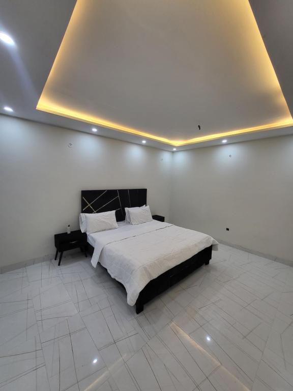a bedroom with a large bed in a white room at Crystal Heights in Lahore
