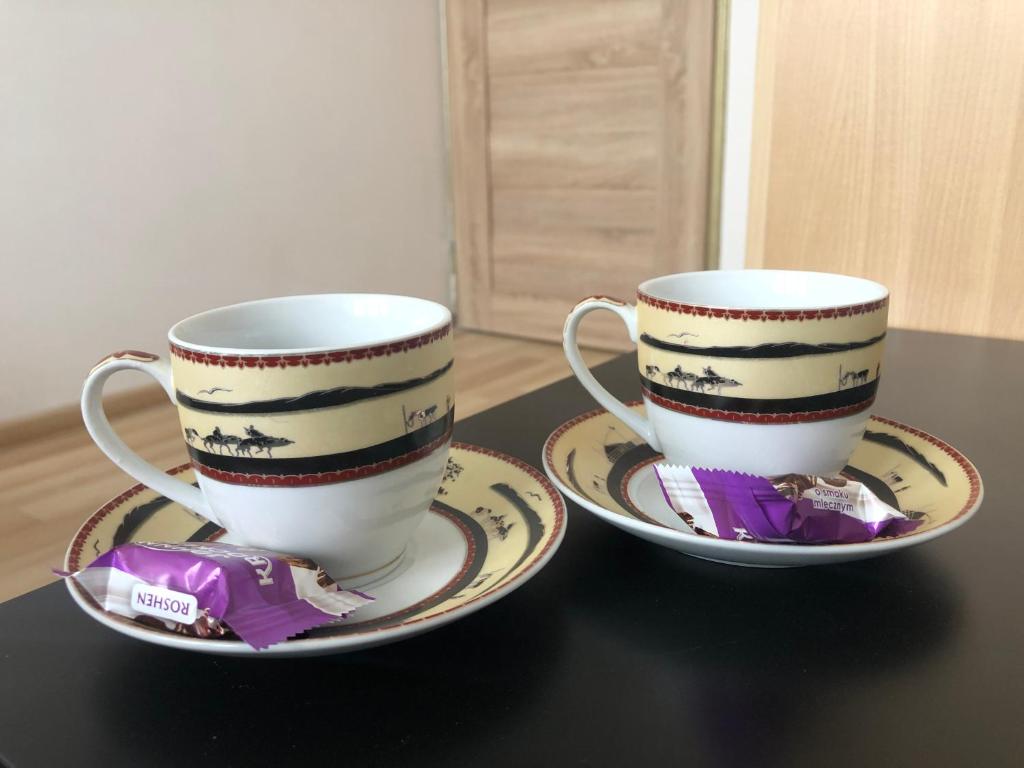 dos tazas de café y platillos en una mesa en Inżynierska - Madera rooms, en Wroclaw
