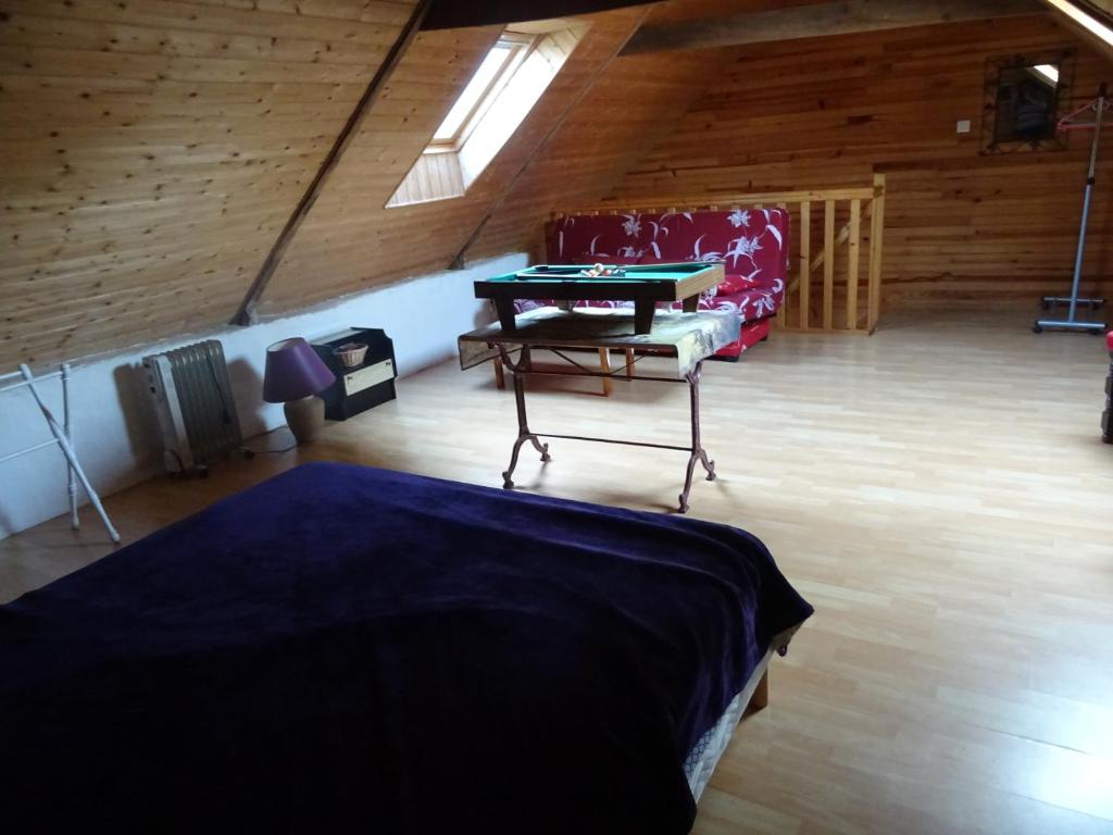 a room with a ping pong table and a chair at Gîte au coeur de la Bretagne in Roudouallec