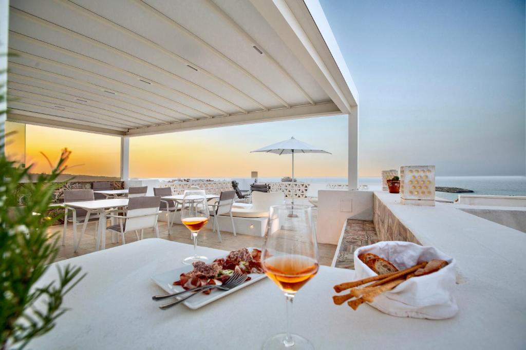 een tafel met twee glazen wijn en een bord eten bij Dimora Del Dragone in Vieste