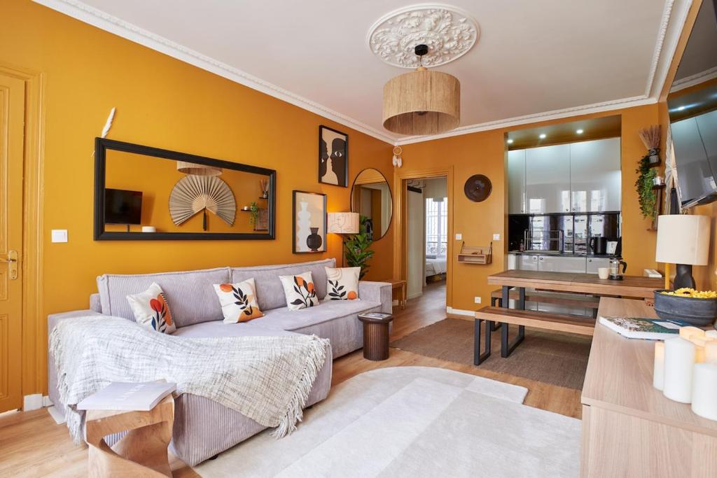 - un salon avec des murs jaunes et un canapé gris dans l'établissement Lovely flat Marais - Orange, à Paris