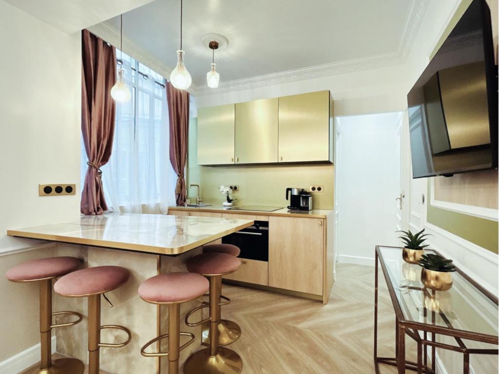 une cuisine avec un comptoir et des tabourets dans une pièce dans l'établissement Merveil - Luxury Suite - Marais - Charlot, à Paris