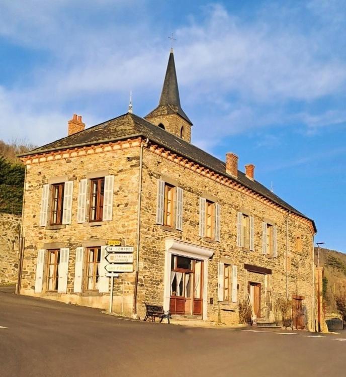 un vieux bâtiment en briques avec une tour en haut dans l'établissement Les Chambres de la Violette, à Grenier-Montgon