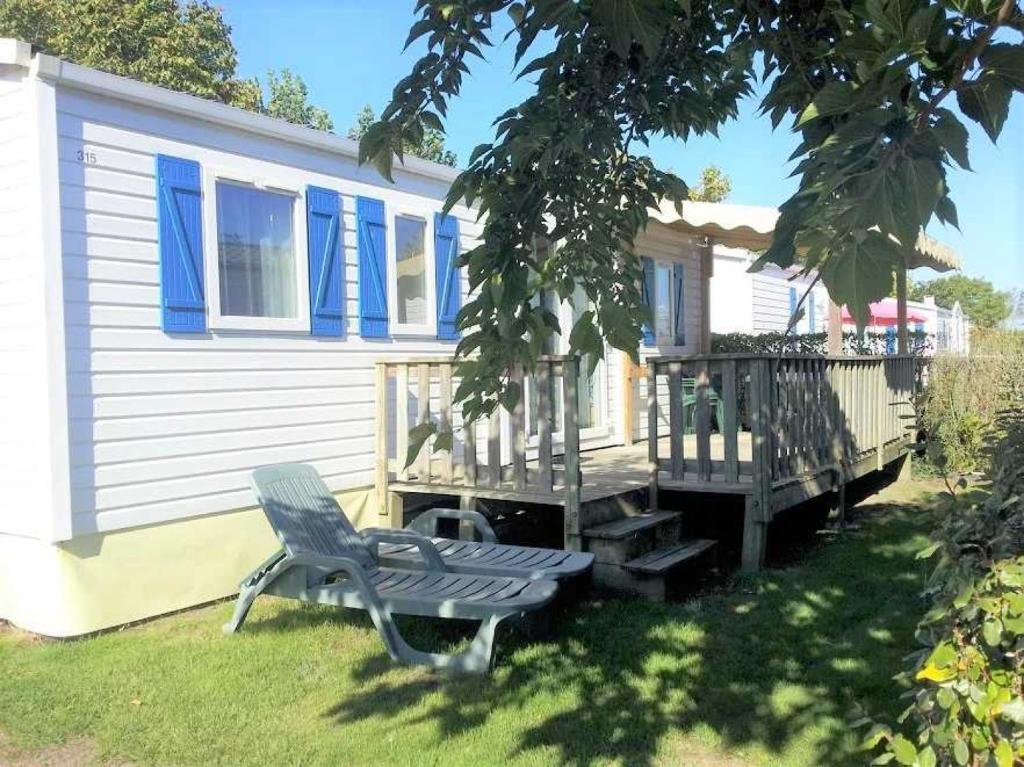 a blue chair sitting in front of a house at Camping 4 étoiles - Parc aquatique - eeia0i in Le Bois-Plage-en-Ré
