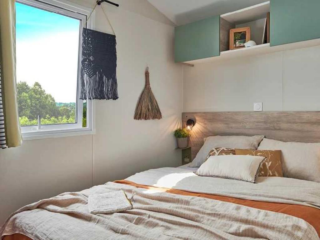 a bedroom with a large bed and a window at Camping 3 étoiles - Piscine - ccbbbf0 in Surgères