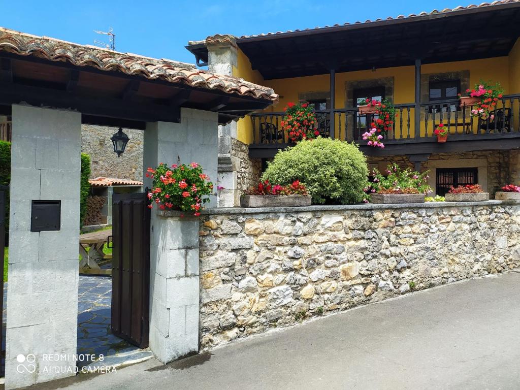 a stone wall with flowers on a building at Gran Pedroso de Llanes in Llanes