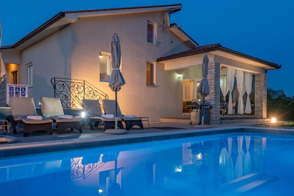 una villa con piscina por la noche en Villa Irene, a quiet and peaceful pool villa, en Nedeščina