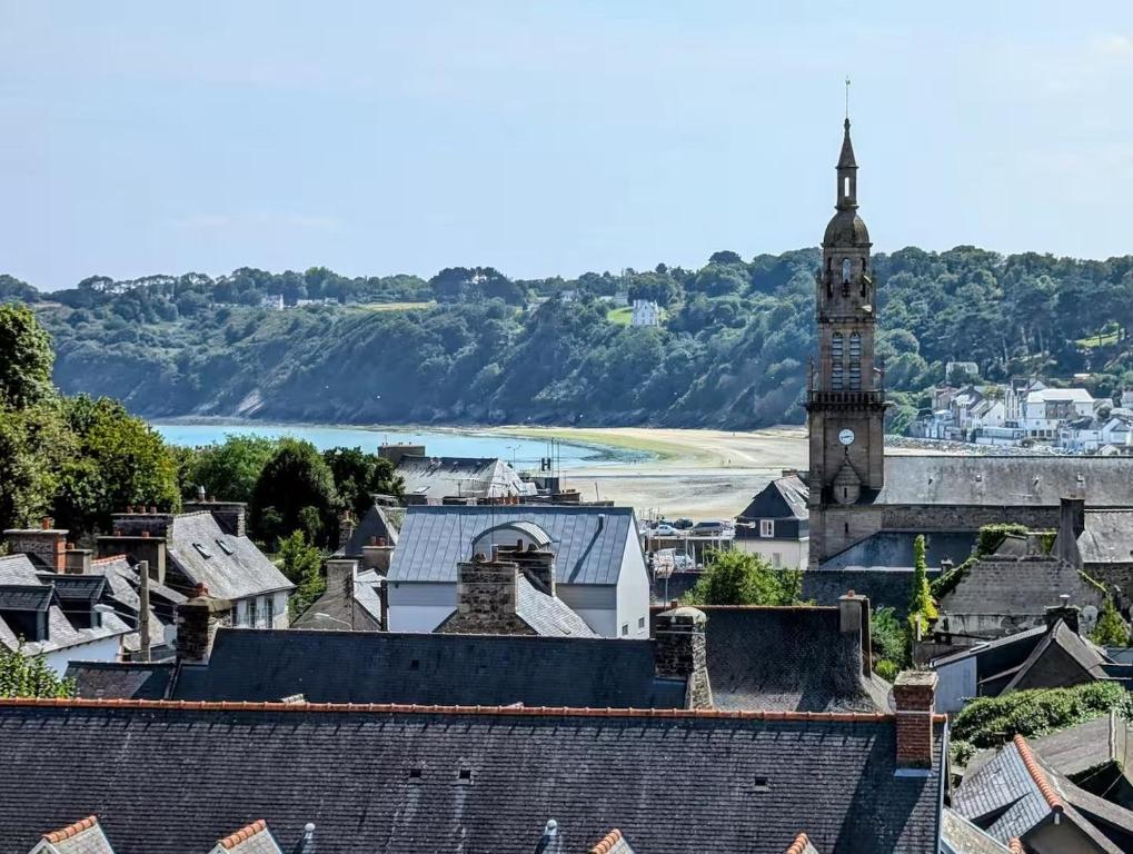 - une vue sur une ville dotée d'une tour de l'horloge dans l'établissement Ker Amel - Vue mer et parking, à Binic