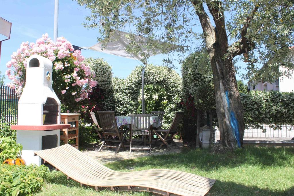 un giardino con una panca in legno e un albero di Appartamento Stella Marina a Marcelli