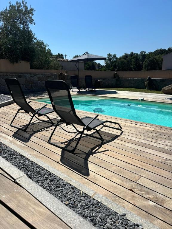 - deux chaises assises sur une terrasse à côté d'une piscine dans l'établissement Casa Vignalledda, à Porto-Vecchio