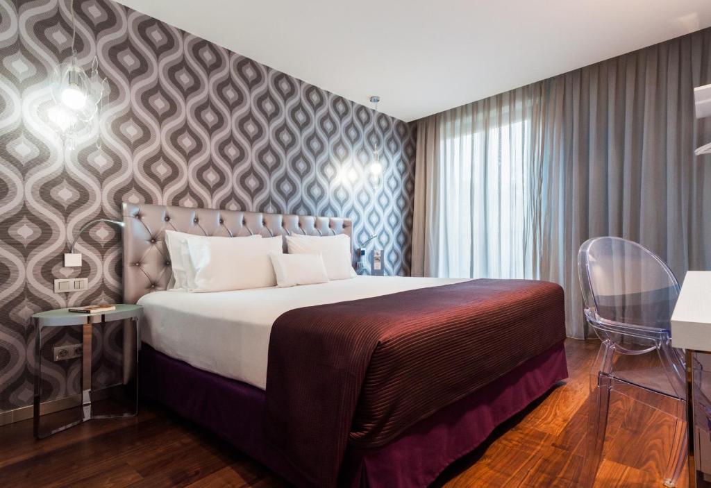 Un dormitorio con una cama grande y una pared con un patrón. en Ikonik Ramblas, en Barcelona