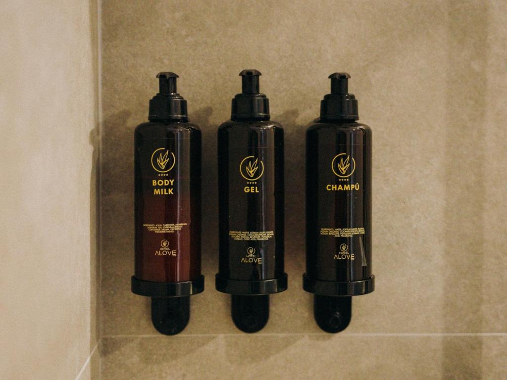 three black bottles are sitting on a wall at HOTEL ALOVE in San José