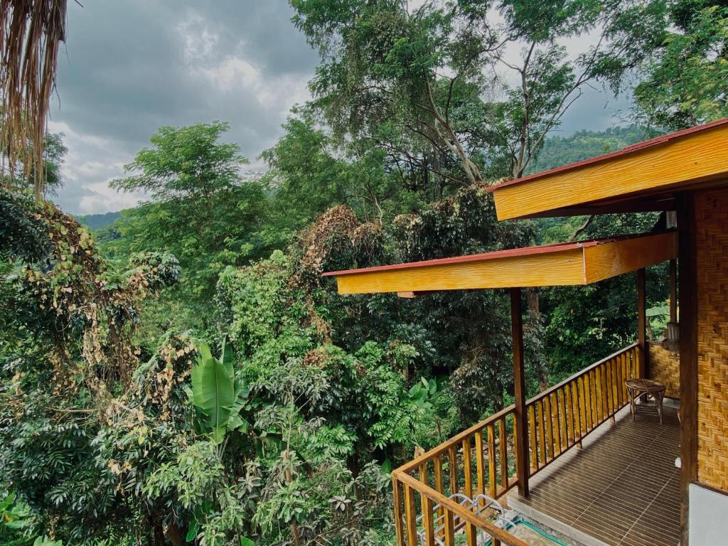 a balcony of a house with trees in the background at Poetri bungalow Superior ROOM in Mantaak