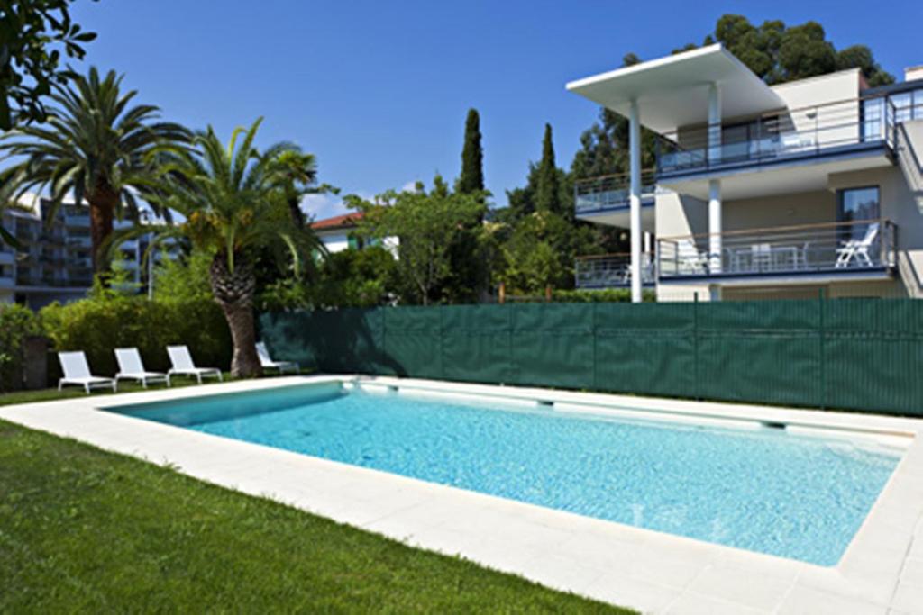 a swimming pool in front of a house at Arthur Properties - Montfleury in Cannes
