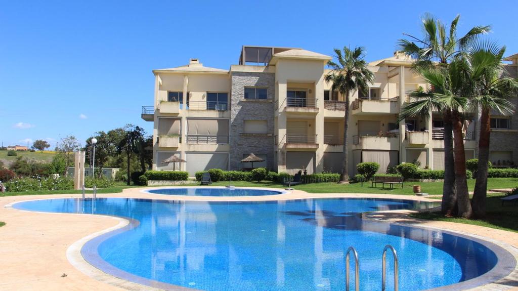 a swimming pool in front of a building at Cozy beach house in Skhirat