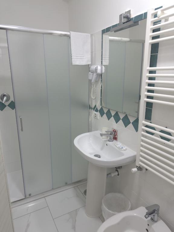 biała łazienka z umywalką i prysznicem w obiekcie B&B Desea w mieście Poggiomarino