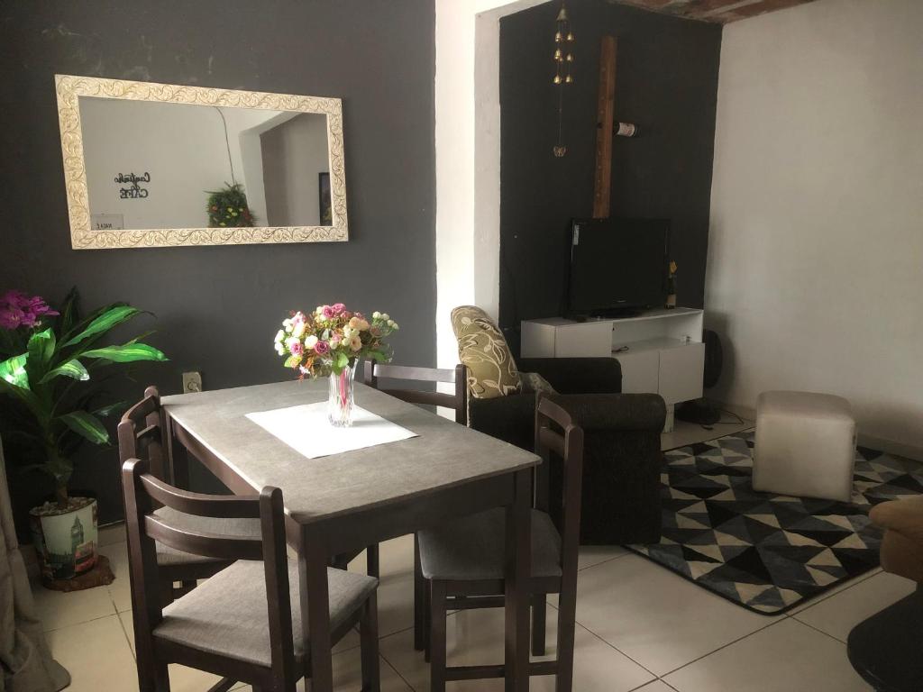 a dining room table with a vase of flowers on it at casinha da Sirlene in Nova Friburgo