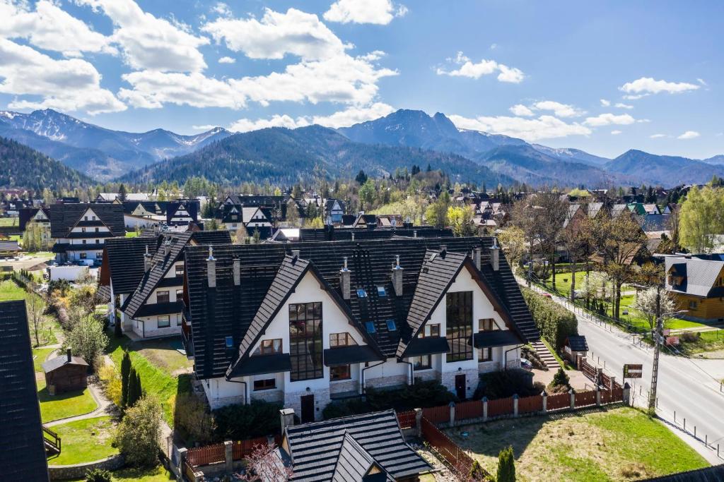 an aerial view of a house with mountains in the background at TatryTop Apartamenty Pardałówka in Zakopane