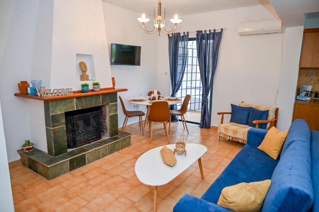 un salon avec un canapé bleu et une cheminée dans l'établissement Blue Waves, à Káto Ássos