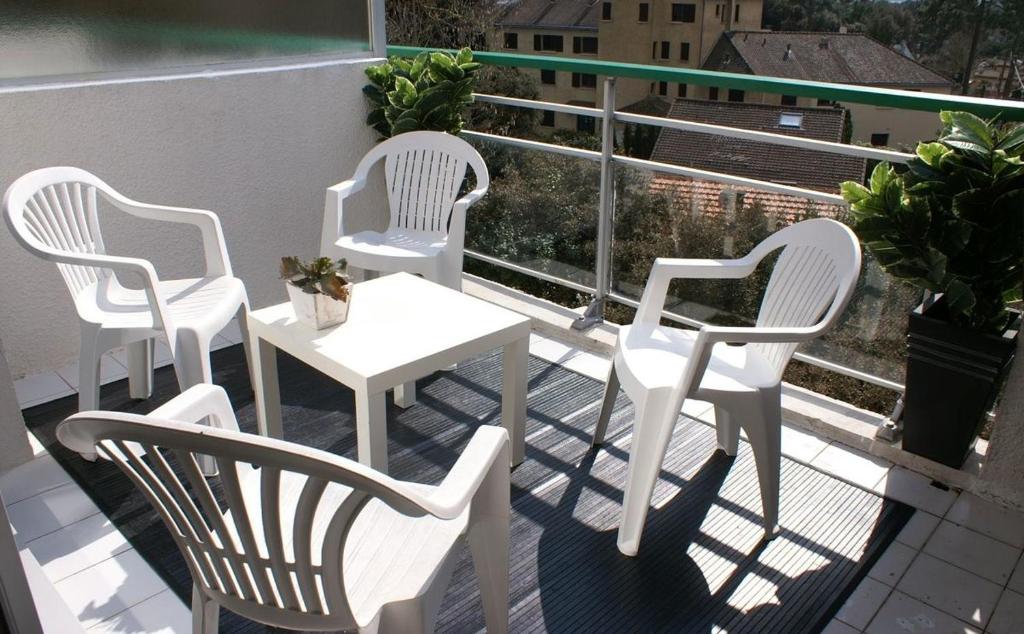 3 chaises blanches et une table sur un balcon dans l'établissement Duplex dernier étage terrasse sud La Baule plage 8mn à pied, à La Baule