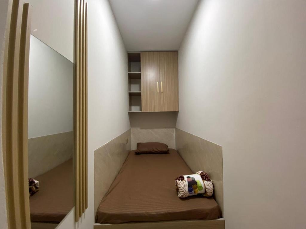 ein kleines Zimmer mit einem Bett und einem Spiegel in der Unterkunft Garden Residence in Dubai