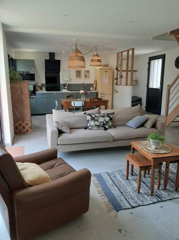 un salon avec deux canapés et une table dans l'établissement Le Bon Temps, pour de jolis moments, à Saint-Martin-lez-Tatinghem