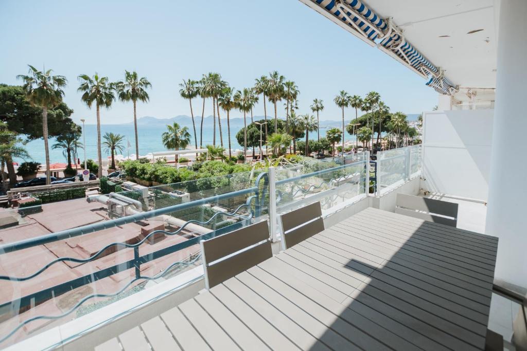 un balcon avec vue sur la plage et les palmiers dans l'établissement Sublime T3 de standing - Croisette Cannes - Vue mer, à Cannes