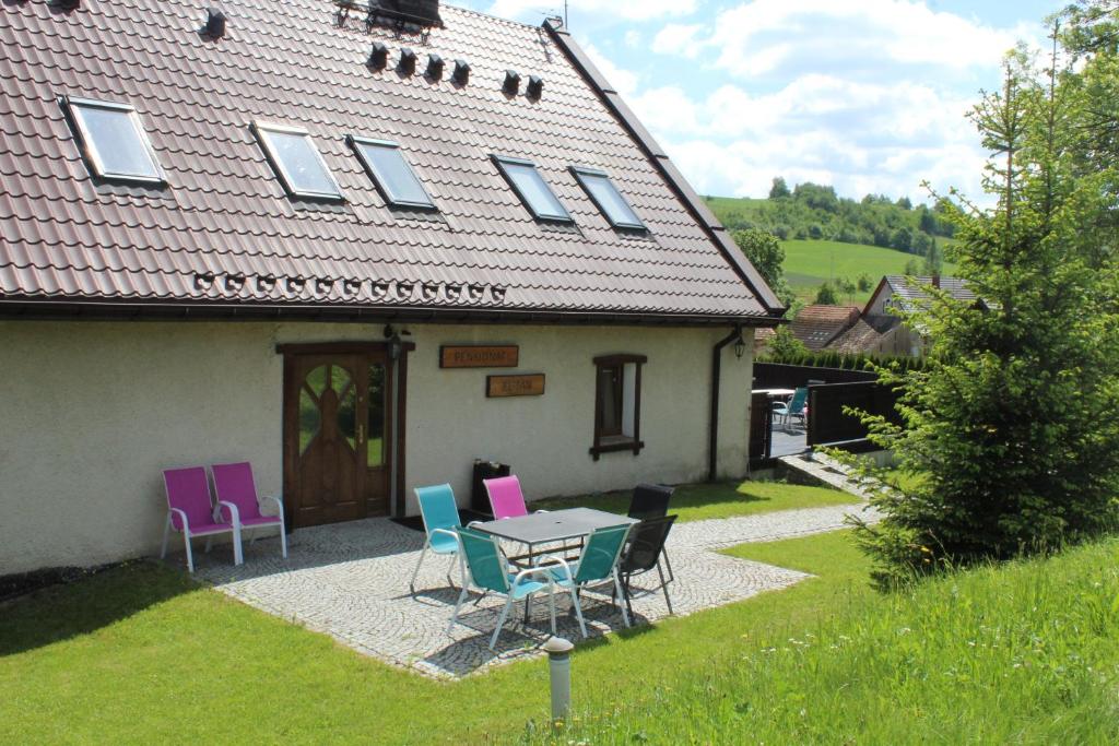 a table and chairs in front of a house at Pensjonat EL-TAN in Złoty Stok