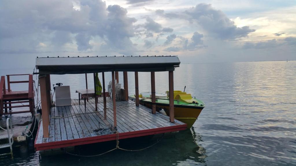 a small boat tied to a dock in the water at Pension de famille HITI MOANA VILLA in Papara