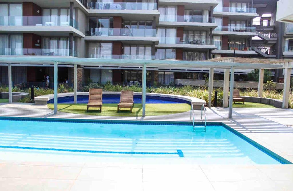 a swimming pool in front of a apartment building at 2 Bedroom combo with pool at Ocean Dune, Sibaya in Umdloti