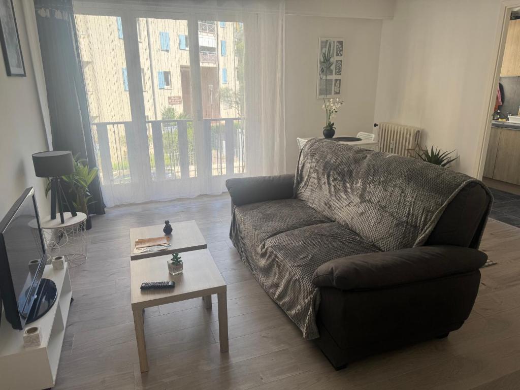 un salon avec un canapé et une table basse dans l'établissement Appartement cosy, à Cannes